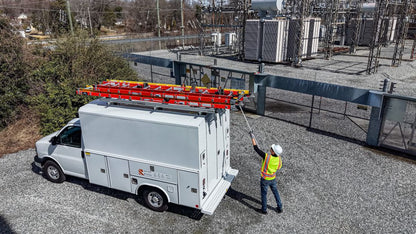 white work truck, worker lowering a drop down ladder rack