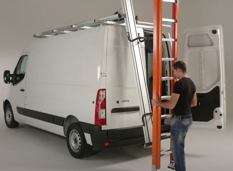 ford transit with worker loading orange ladder at the rear of the van