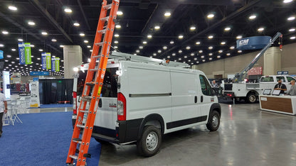 white ram promaster work van at trade show with drop down ladder rack with orange ladder