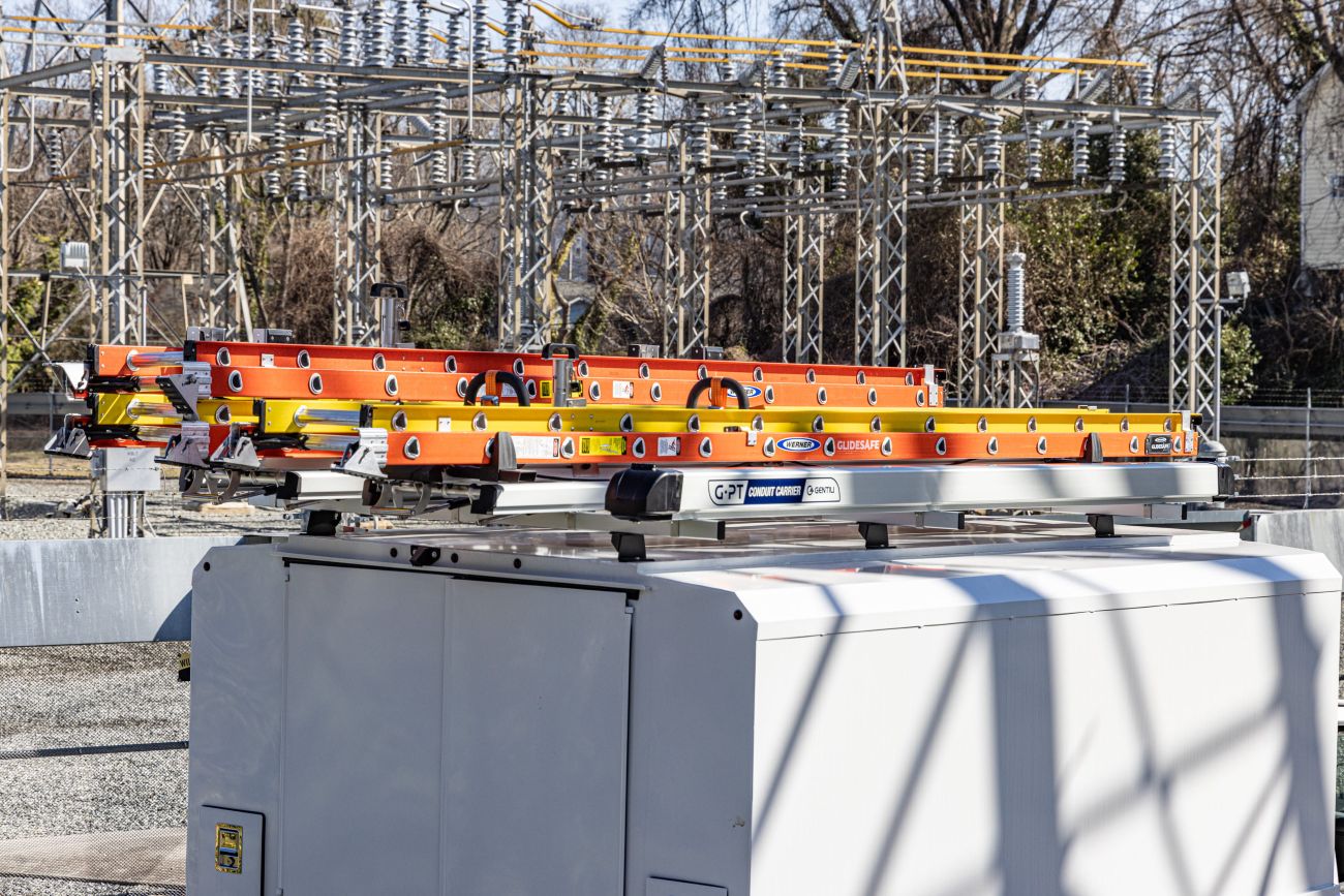 conduit carrier on van roof rack with orange ladders on drop down ladder rack