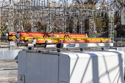 conduit carrier on van roof rack with orange ladders on drop down ladder rack