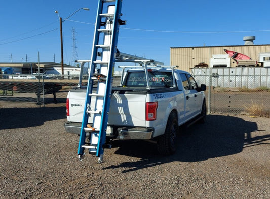 white work fleet truck with truck lumber rack and ladder on drop down ladder rack